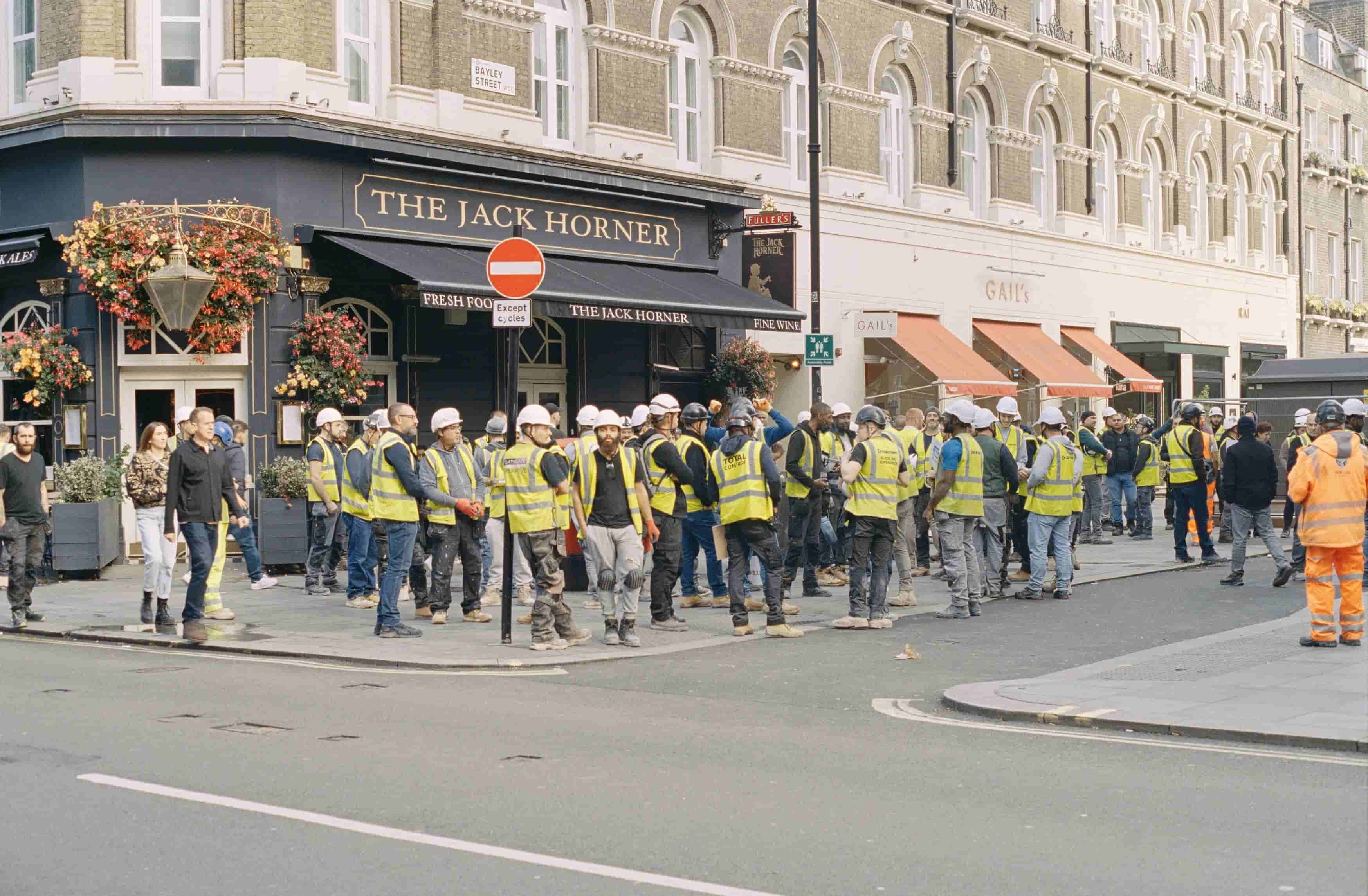 Workers standing in front of the pub after a long day of work